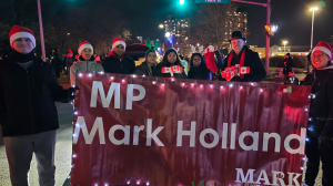 MP and staff gathered around an MP Mark Holland banner in a parade