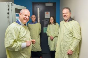 Minister Holland with staff in medical garments to tour SickKids Research Institute