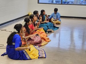 A group of young performers play musical instruments in cultural clothing